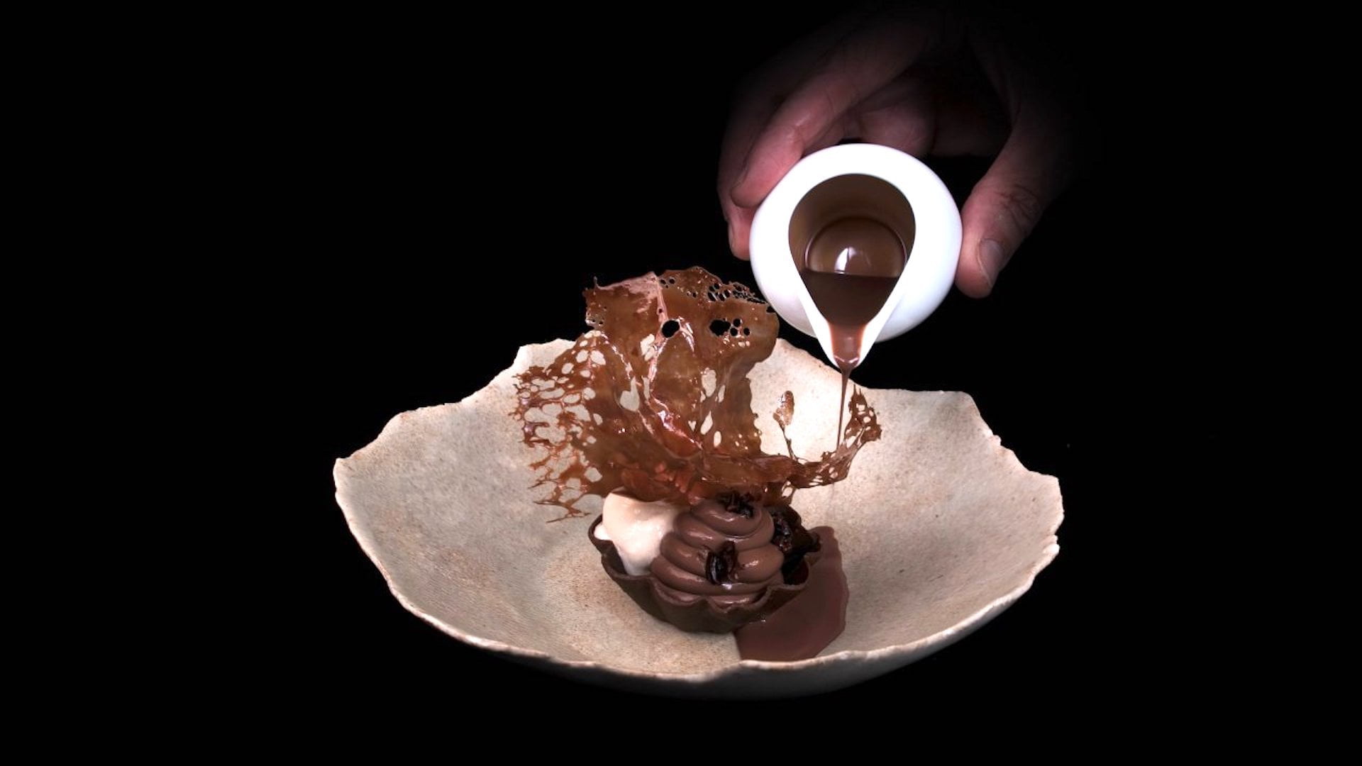 Ein appetitliches Schokolade-Dessert vor schwarzem Hintergrund.