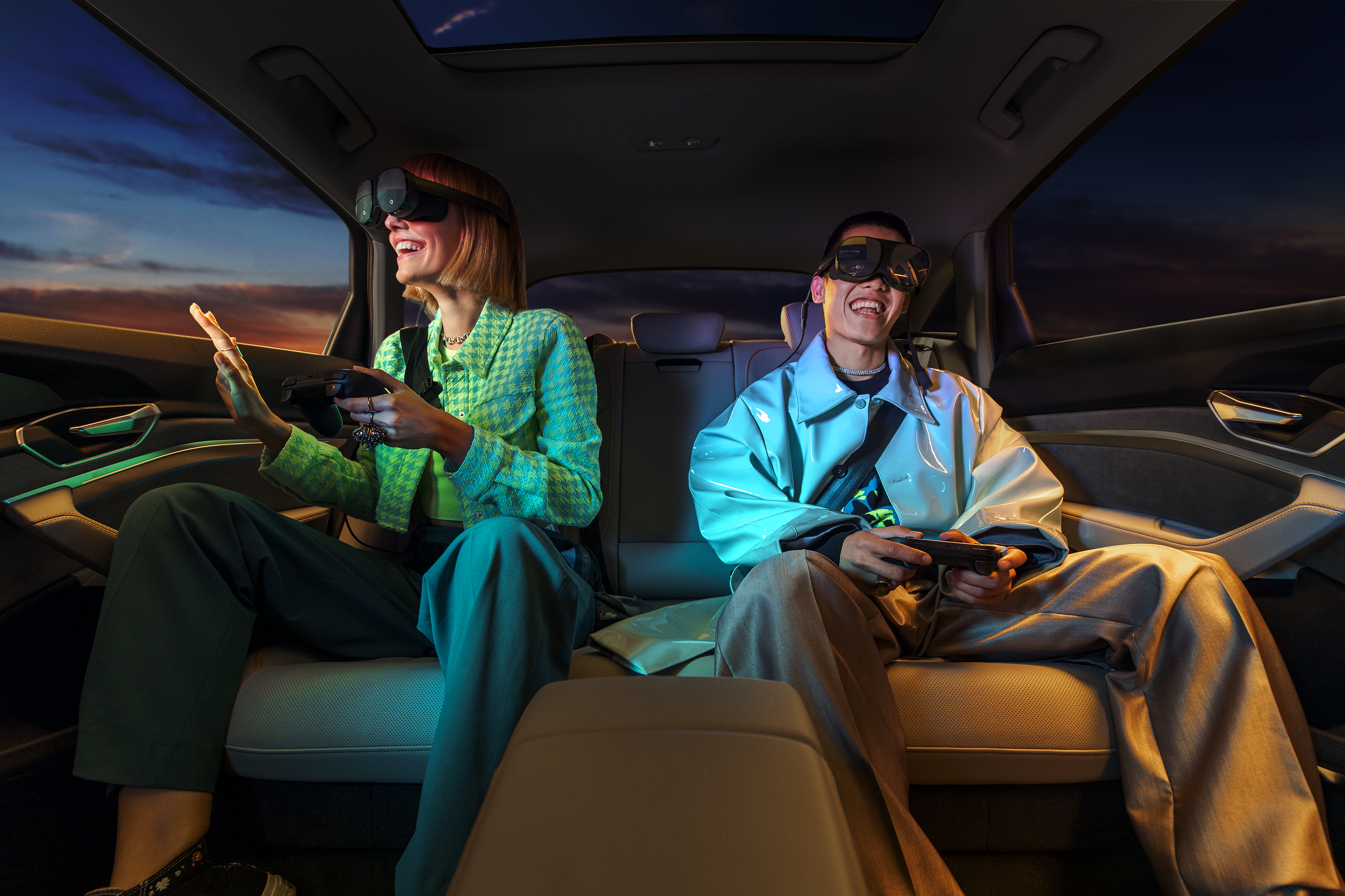Eine Frau und ein Mann auf der Auto-Rückbank nutzen fröhlich grinsend das Auto-VR-System Holoride.